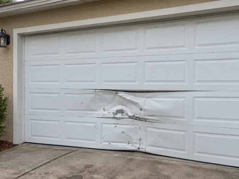 Dented garage door panel from vehicle impact damage in Southwood